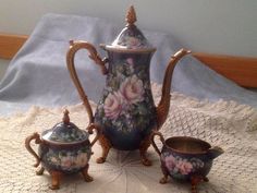 an ornately decorated tea set on a doily