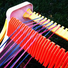 an assortment of colorful toothpicks in a plastic container on the grass, with one being pulled up by a string