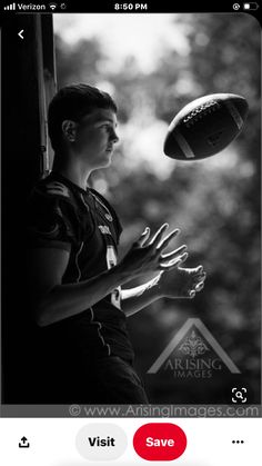 a young man holding a football in his right hand while standing next to a window