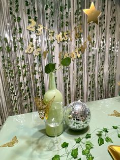 a table topped with a vase filled with flowers and a disco ball next to it