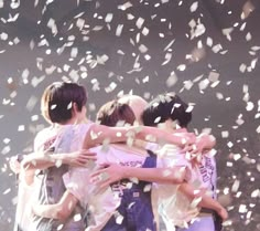 group of boys hugging each other with confetti in the air