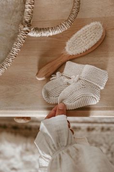 Oat Baby Booties on a dresser next to a hairbrush and basket Baby Stork, Names Girl, Baby Knitwear, Best Baby Shower Gifts, Baby Bundles, Luxury Baby, Moss Stitch, Knitted Baby, Baby Outfits