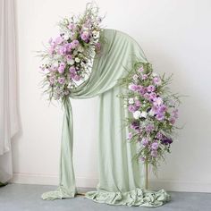 the flowers are arranged on the floor next to the drapes and draped fabric for decoration