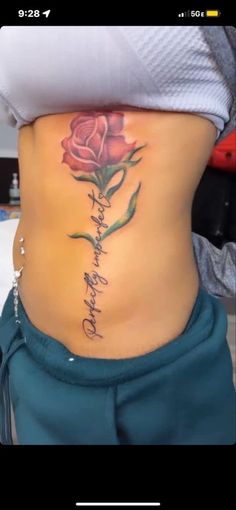 a woman's stomach with a rose tattoo on her lower back and words written in cursive writing