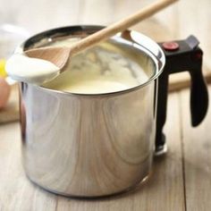 a wooden spoon sticking out of a pot filled with liquid