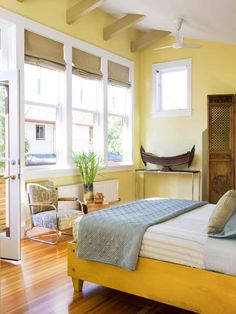 a bedroom with yellow walls and wooden floors