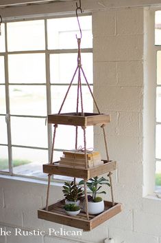 a hanging planter filled with succulents and plants in front of a window