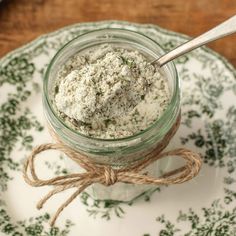 a glass jar filled with food sitting on top of a plate next to a spoon