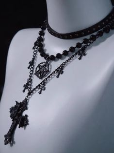 Unveil your dark, mystical allure with our Black Gothic Triple Layered Necklace. The necklace boasts a sophisticated triple-layered design, each chain meticulously crafted to fall at different lengths. The second layer is adorned with a prominent hexagram pendant. Complementing the hexagram, the third layer features cross pendants, embodying gothic influences. Mystical Black Jewelry For Party, Halloween Black Chain Choker, Punk Style Black Chain Necklace, Black Double Strand Necklace For Party, Black Mystical Choker Necklace, Black Gothic Choker With Chain, Black Gothic Chain Choker, Mystical Black Choker Necklace, Mystical Style Black Choker Jewelry