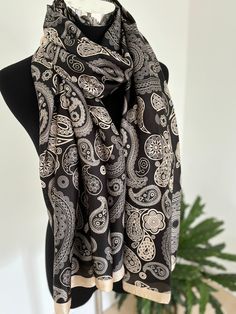 Size: 189*90cm Experience the timeless elegance of traditional Indian design with this exquisite black and cream scarf. Featuring intricate patterns inspired by Indian artistry, this scarf adds a touch of cultural sophistication to any ensemble. Made from premium polyester silk, it offers a luxuriously soft feel and a lightweight drape, ensuring both comfort and style. Whether you're dressing up for a special event or enhancing your everyday look, this versatile accessory is perfect for any occa Traditional Black Silk Scarves, Black Bohemian Silk Scarf, Elegant Patterned Silk Scarf With Paisley Print, Elegant Silk Scarf With Paisley Print, Elegant Pashmina Shawl With Paisley Print, Elegant Pashmina Silk Scarf With Paisley Print, Elegant Silk Scarves With Paisley Print, Elegant Patterned Shawl Scarves, Elegant Patterned Shawl Scarf