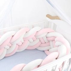 a white crib with pink and white chains in it