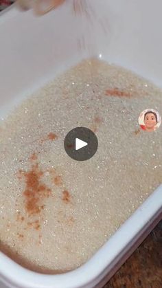 a bowl filled with rice and brown stuff on top of a wooden table