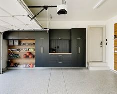 an empty garage with black cabinets and shelves