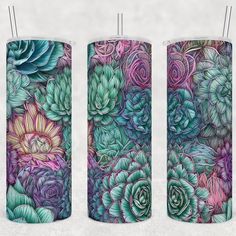 three candles with floral designs on them, one is purple and the other is green