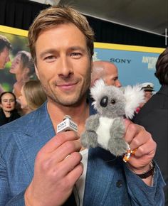 a man holding a stuffed koala in his right hand