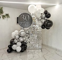 balloons and streamers in front of a sign that reads 30 years of life