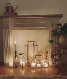 candles are lit in front of a fireplace