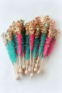 several different colored toothpicks with gold and green glitter on them sitting next to each other