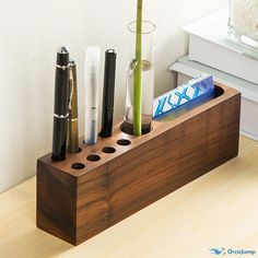 a wooden holder with pens and other items in it