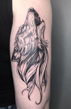 a woman's arm with a wolf tattoo on the left side of her body