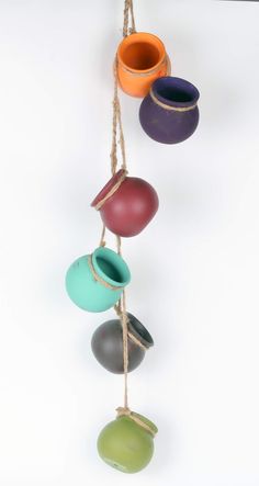 several different colored vases hanging from a rope