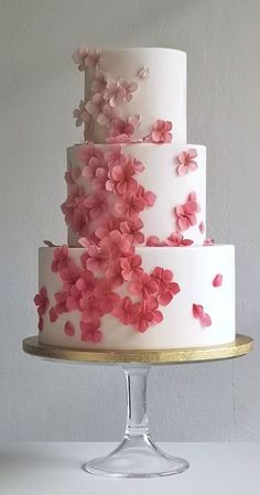 a three tiered cake with pink flowers on it