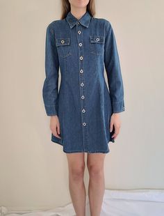 "1990s long sleeve, two front chest pockets, two pockets on back, hits just above the knee tagged size large, I think it fits a bit more like a medium, see measurements for fit measurements: length 33\", waist 32\", pit-to-pit 19\"  100% cotton, machine wash, made in USA excellent pre-owned condition, no flaws or damage Feel free to bundle with other items Items are pre-owned with possible flaws as expected with vintage. Major flaws will be noted in description." Long Sleeve Denim Dress With Pockets For Work, Fitted Long Sleeve Denim Dress With Pockets, Long Sleeve Medium Wash Denim Dress With Pockets, Long Sleeve Denim Dress With Buttoned Pockets, Casual Long Sleeve Denim Dress With Pockets, Long Sleeve Denim Dress With Buttons, Dark Wash Long Sleeve Denim Dress With Pockets, Long Sleeve Dark Wash Denim Dress With Pockets, Long Sleeve Dark Wash Denim Dress With Buttons