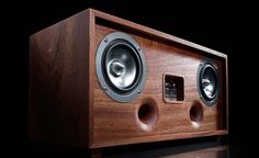 the speaker is made out of wood and has two subwoofs on each side