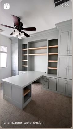 an empty room with lots of cabinets and a ceiling fan in it's center