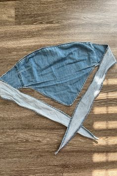 a pair of scissors laying on top of a piece of denim material that has been cut in half