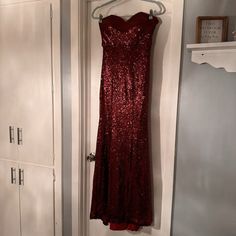 a red dress hanging on a white door