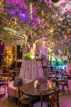 the interior of a restaurant with tables, chairs and chandeliers hanging from the ceiling