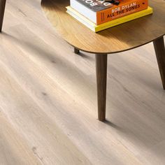 a coffee table with two books on it and a chair in the corner behind it