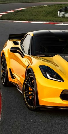 a yellow sports car driving on a race track