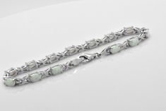 Here we have a beautiful lab created White Opal Sterling Silver tennis Bracelet. Opals feature cabochon oval cut in prong setting. Bracelet is about 5 carats of gemstone total weight. This bracelet was designed to allure and impress. It will be an excellent addition to a jewelry collection due to its unique design. The bracelet is made out of solid 925 Sterling Silver and 14k white gold overlay for that timeless and classic look. Brand new item, never worn. Other lengths available per especial r Oval Cabochon Bracelet In Fine Jewelry Style, Oval Cabochon Bracelets For Formal Occasions, Formal Oval Sterling Silver Bracelet With Polished Finish, Oval Cabochon Bracelets Fine Jewelry, Oval Cabochon Bracelet Fine Jewelry, Fine Jewelry Cabochon Bracelets As Gift, Oval Link Gemstone Bracelets For Anniversary, Silver Oval Link Jewelry With Gemstone, Silver Oval Cabochon Bracelet