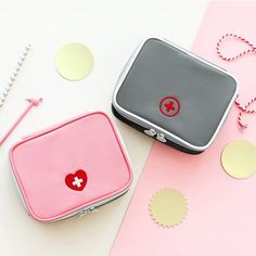 two small purses sitting next to each other on a pink and white table with confetti