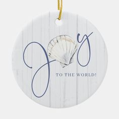 a white ornament with the word joy to the world written on it and a seashell