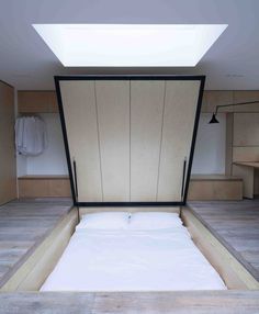 an empty bed in the middle of a room with wooden walls and flooring on both sides