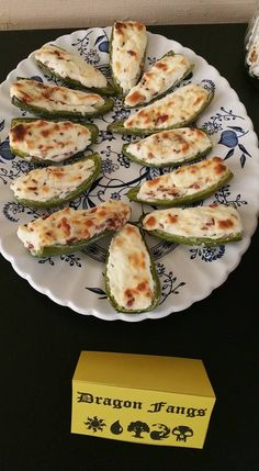 some food is on a white plate with blue and yellow designs, along with a box of crackers