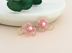 Our glass flower earrings are the perfect accessory for anyone who loves the beauty and grace of cherry blossoms.  Symbolizing renewal and hope, Sakura blooms are a unique birthday gift for gardeners, nature and plant lovers. Each pink flower is hand-woven with petal and seed beads in soft shades of pink, that will add a touch of floral charm to your spring and summer ensembles. Customize your handmade jewelry by choosing leverback earrings or hand-crafted hook ear wires available in 14k gold fi Feminine Blossom Earrings For Gift, Feminine Flower Earrings With Ear Wire For Gifts, Petal-shaped Flower Earrings For Gifts, Petal Shaped Flower Earrings As Gift, Petal Shaped Flower Earrings With 3d Flowers, Delicate Pink Flower Earrings For Anniversary, 3d Flower Petal Earrings, Glass Flower Earrings, Sakura Bloom