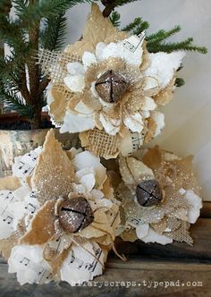 three flowers are sitting on top of sheet music paper and some pine branches in the background