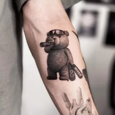 a person with a bear tattoo on their arm holding a baseball bat and mitt