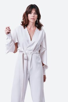 The minimalist white of our Junin jumpsuit belies its sophisticated structure, with elegantly slashed, deconstructed long sleeves creating a cape-like effect. The wrap-style design features a straight-leg silhouette, cinched at the waist with an extra-long belt. Just add statement earrings. Silk-cotton crepe Specialist clean Minimalist White, White Jumpsuit, Style Design, Wrap Style, Extra Long, Statement Earrings, Design Features, Cape, Straight Leg