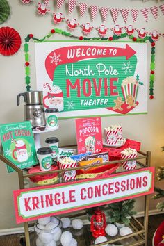 a christmas movie theater display with popcorn, movies and other holiday treats on it's stand