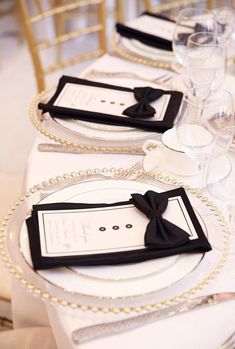 the table is set with white and black place settings