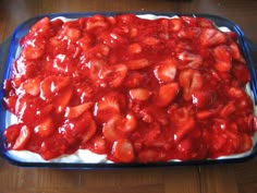 a blue casserole dish filled with strawberries