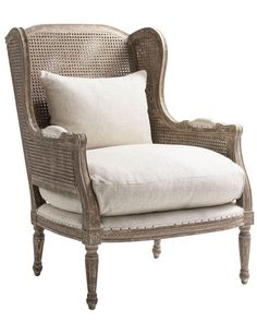 an old style chair with white pillows on it's back and armrests