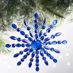 a blue ornament hanging from a christmas tree