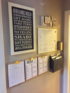 a wall with calendars and other items hanging on it's sides, along with two small file folders