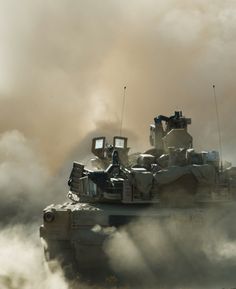 an army tank is driving through the dust